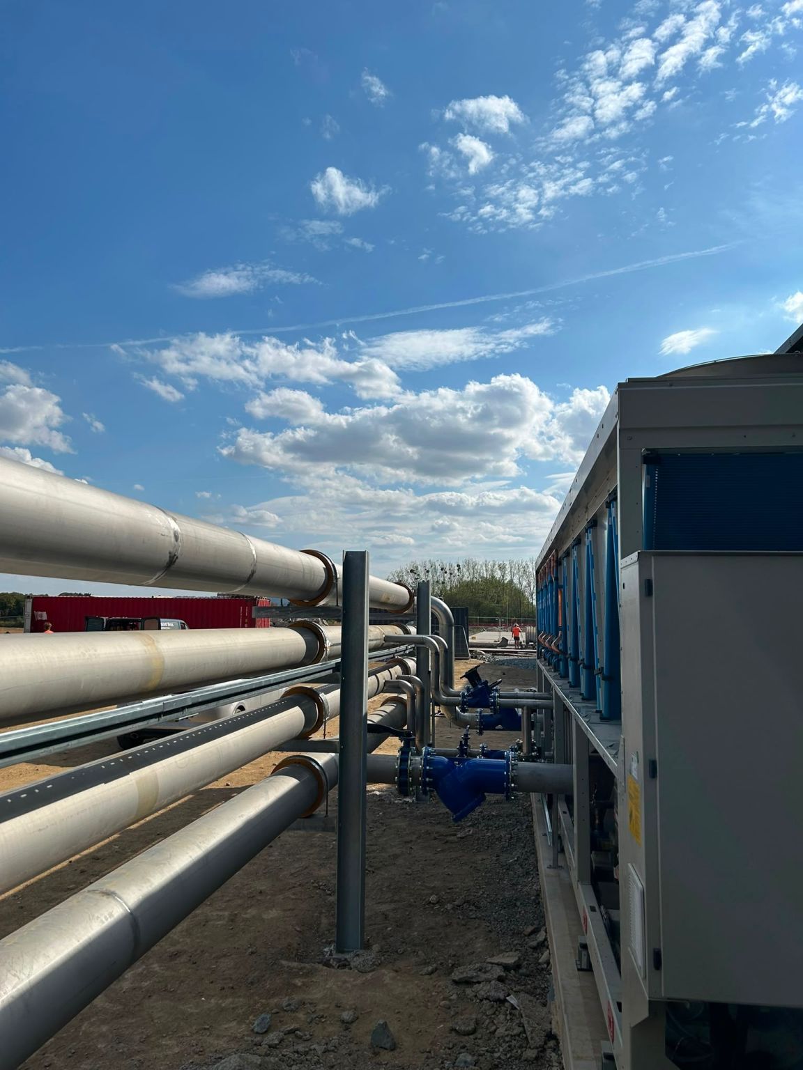 Cable tray running alongside insulated pipework towards external plant on a site in Evesham