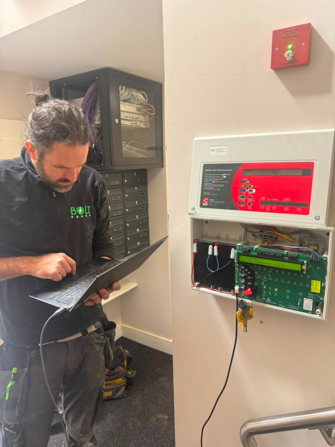 Bolt Group engineer with a laptop connected to a sprinkler alarm panel