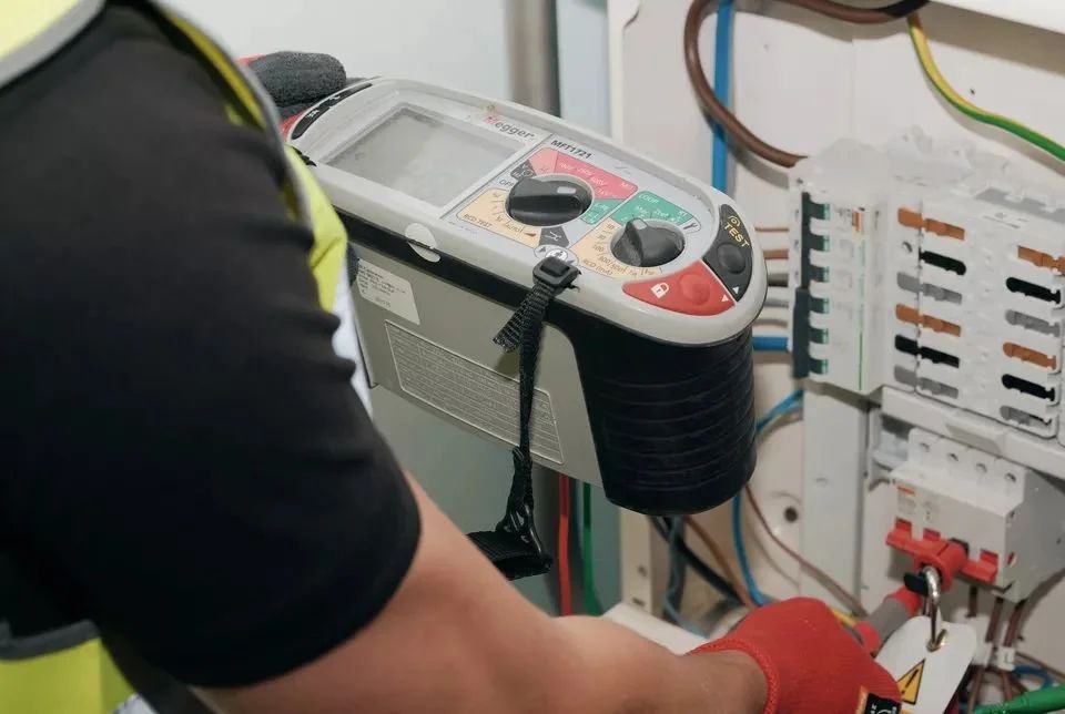 Multifunction tester connected to a distribution board during an inspection